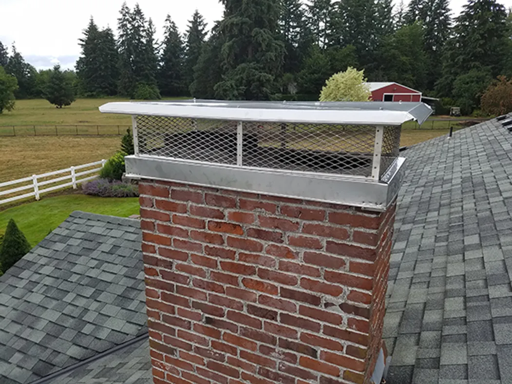 Before and after comparison of a rusted chimney cap replaced with a new stainless steel spark arrestor in Vancouver WA